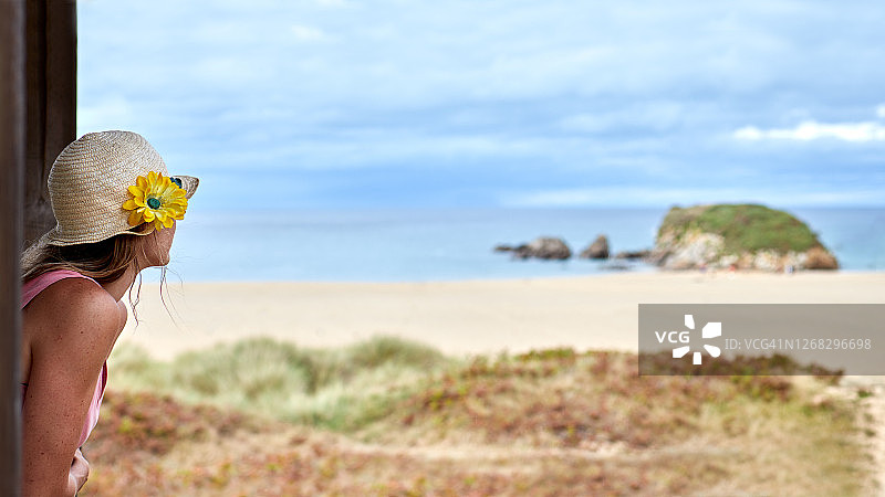 戴帽子的女人在瞭望台看海图片素材