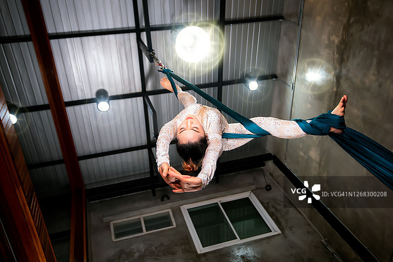 健康生活方式概念：年轻女子进行重力飞行瑜伽伸展运动图片素材