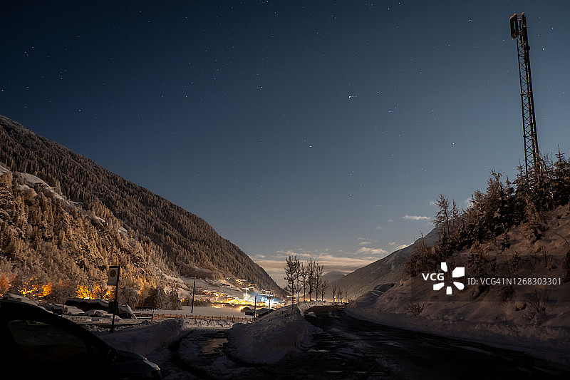 山脉背景下的冬夜：奥地利施图拜山谷新施蒂夫镇的寂静星空图片素材