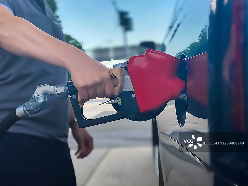 成年男子手持加油泵时使用餐巾纸图片素材