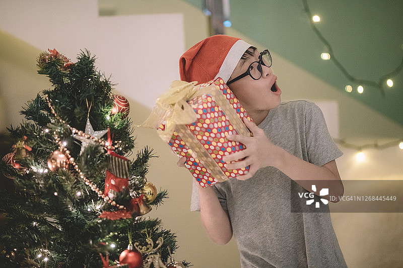 亚洲男孩从父母那里收到圣诞礼物图片素材