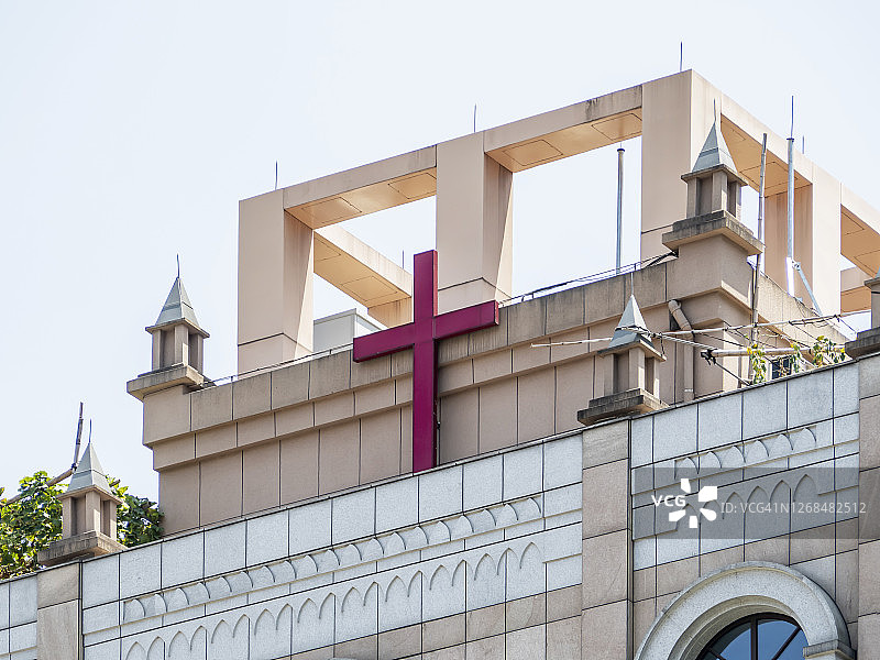 中国杭州一条空旷道路上基督教教堂上的红色十字标志图片素材