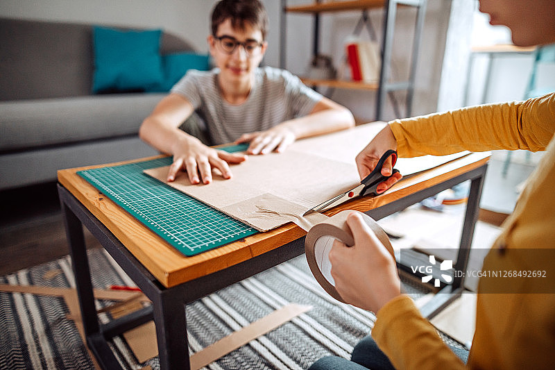 兄妹用纸板制作狗屋图片素材