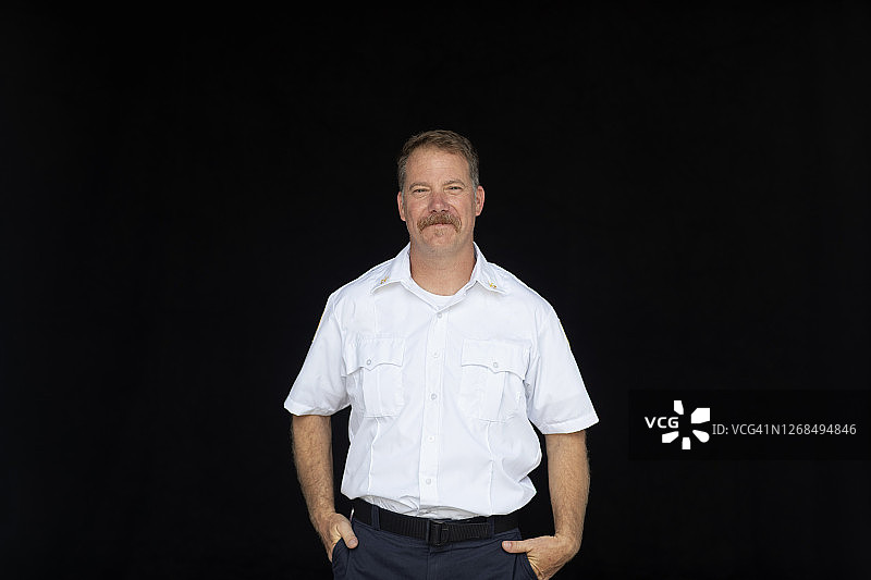 黑色背景上的非紧急制服消防队长肖像图片素材