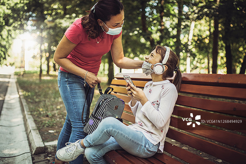 母亲送活泼的女儿去上学图片素材
