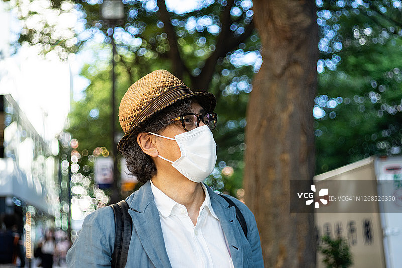 戴着口罩走在东京街头的男人图片素材