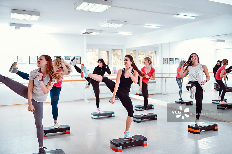 女性在现代健身房上的有氧搏击操课程图片素材