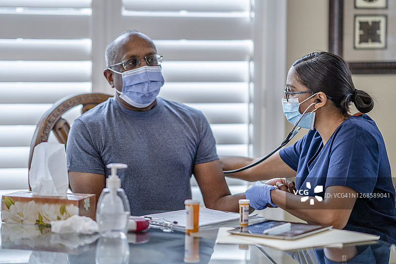 正在患者家中进行家访的女医务专业人员图片素材