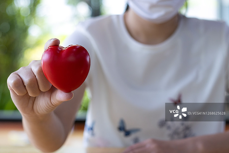 女人手捧着心，心脏病概念图片素材