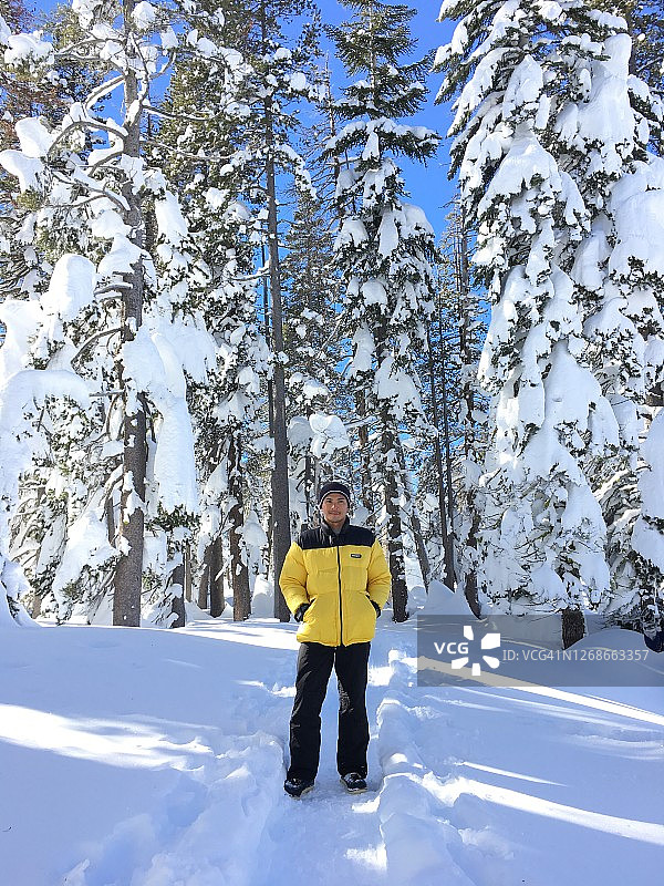 一个穿着黄色夹克的男人在雪地里图片素材