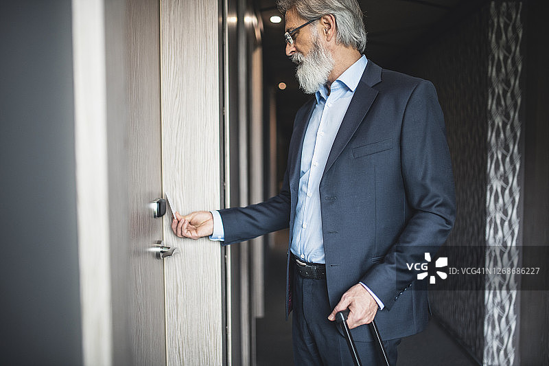 商人使用无钥匙门卡进入酒店房间图片素材