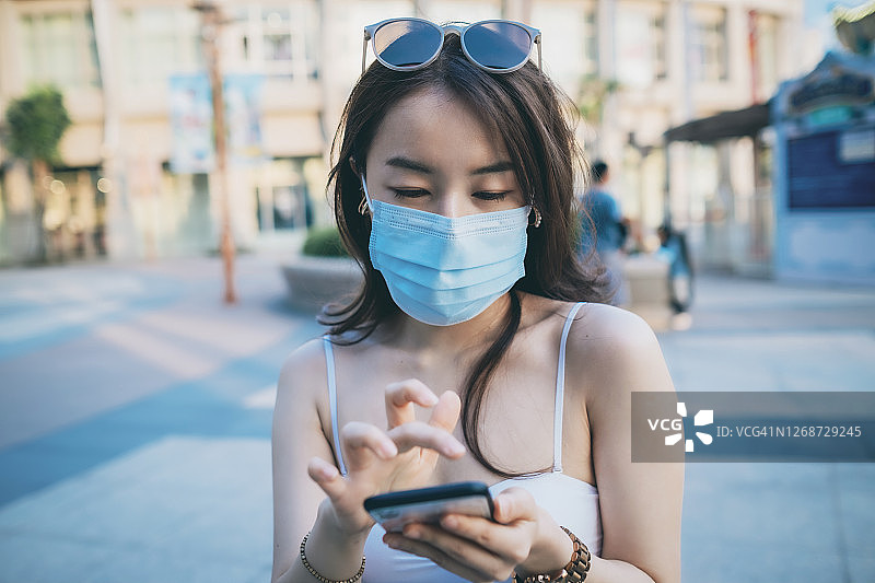 年轻的亚洲女人使用手机图片素材