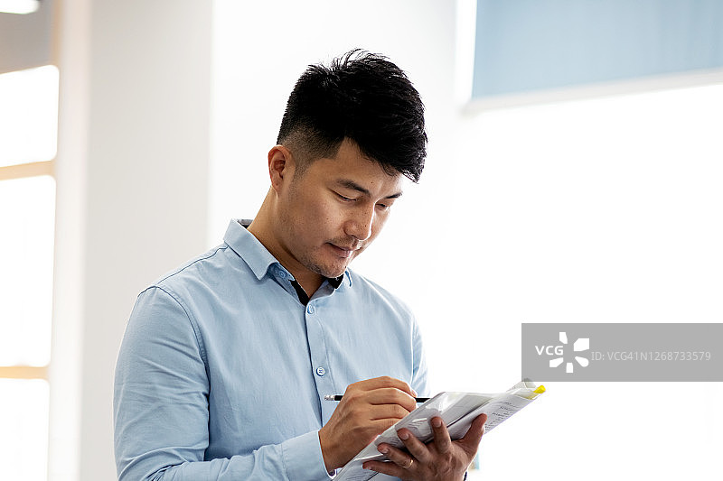 埋头写作的年轻男职员图片素材