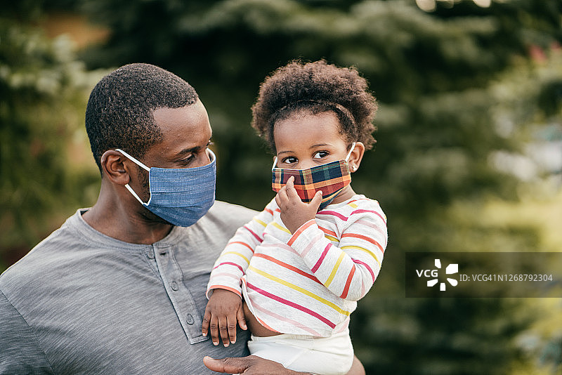 生活片段：真实的家庭瞬间，爸爸和女儿戴着防护口罩图片素材