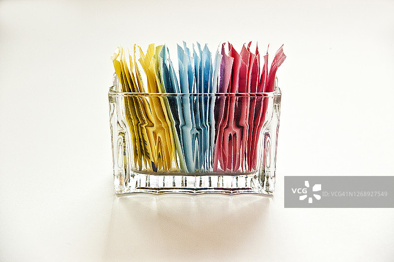 白色背景上的透明玻璃容器中的人造甜味剂图片素材