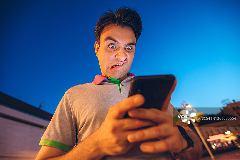 表情滑稽的男子震惊地使用手机图片素材