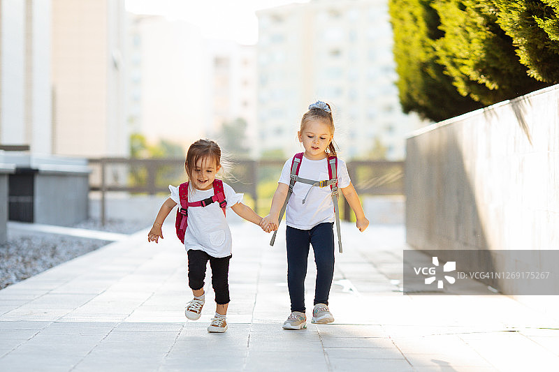 两个孩子去上学。学校、学习、教育、友谊、童年的概念图片素材