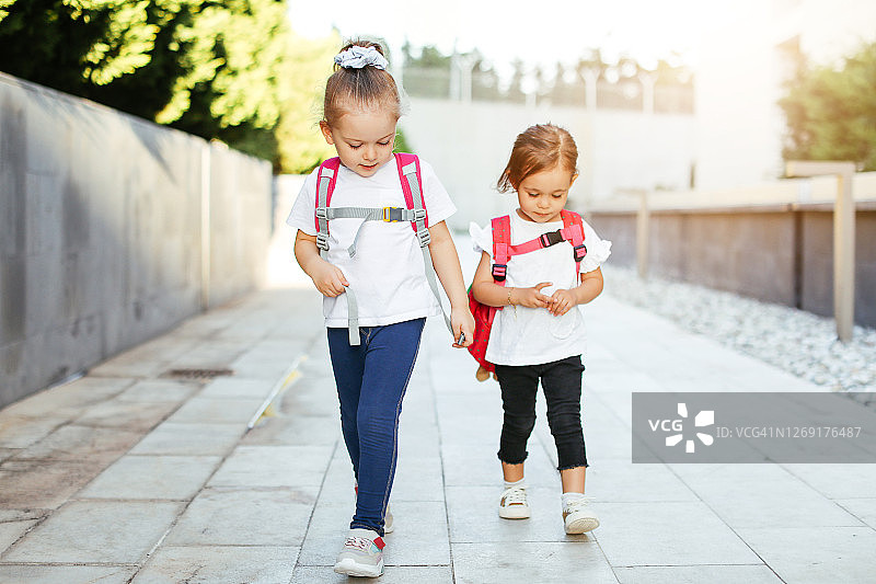 两个孩子去上学。学校、学习、教育、友谊、童年的概念图片素材
