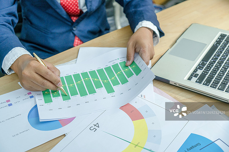 商人分析数据图表，使用计算器计算数字：商业金融与会计概念图片素材