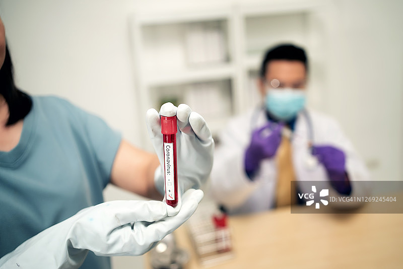 手持新冠病毒血样试管的医生图片素材