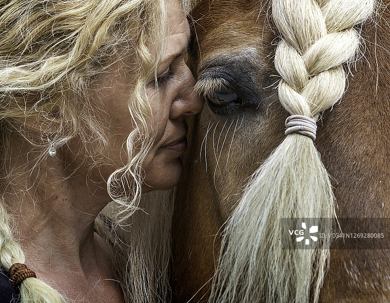 发型相同的女士与马匹亲密互动图片素材