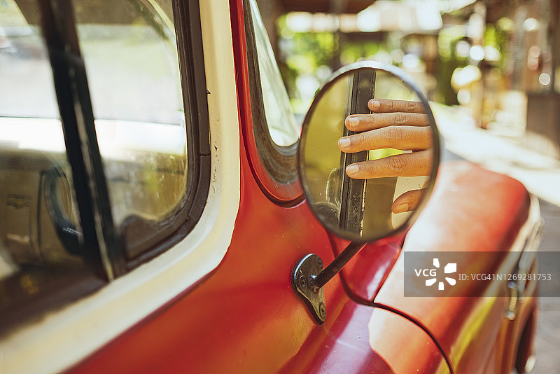 经典汽车侧视镜中手的倒影图片素材