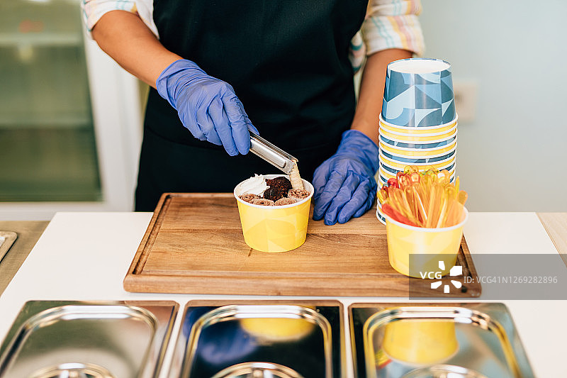 冰淇淋店里快乐的棕发女店员图片素材