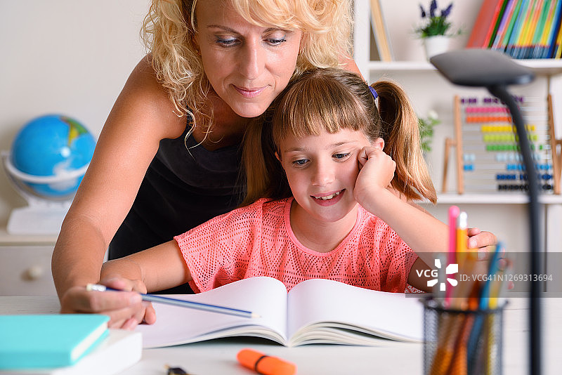 母亲帮助女儿在家学习图片素材