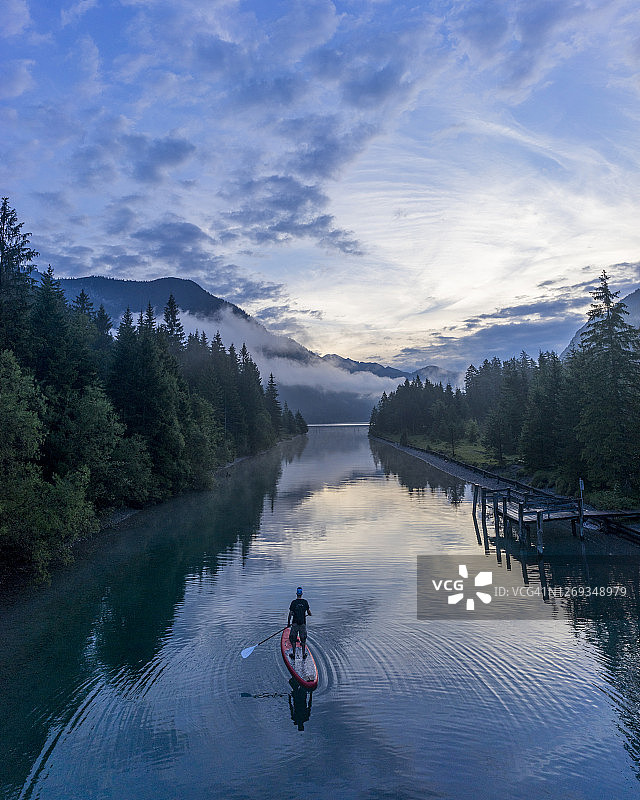 傍晚在奥地利蒂罗尔Plansee湖上玩桨板的男人图片素材