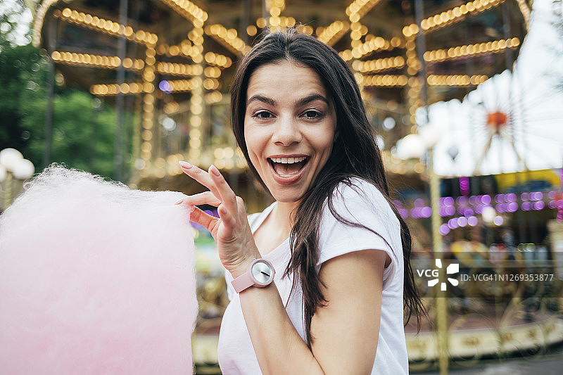 游乐园里拿着棉花糖的美丽女人特写图片素材