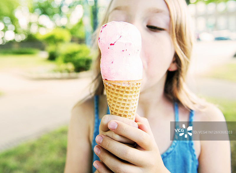 女孩舔草莓冰淇淋甜筒图片素材