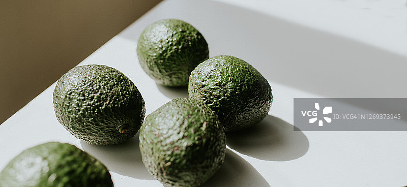 白色表面上投下阴影的5个鳄梨图片素材