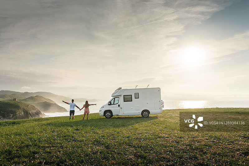 年轻情侣开着房车在海边旅行图片素材
