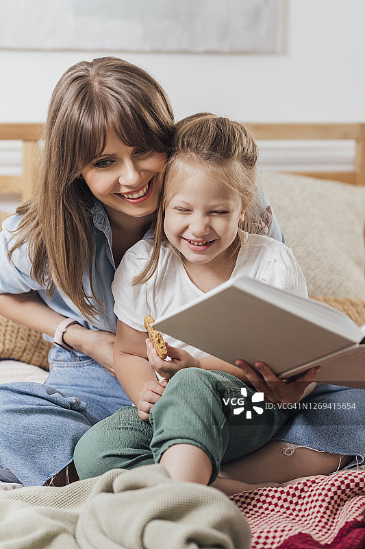 一起阅读：母亲在卧室里给女儿读书图片素材