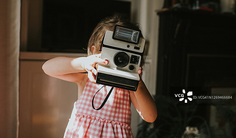 女孩用一次成像相机拍照图片素材