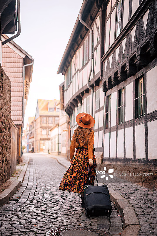 独自旅行者在街上拉着行李箱图片素材