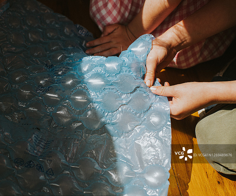 儿童捏破蓝色泡泡膜图片素材