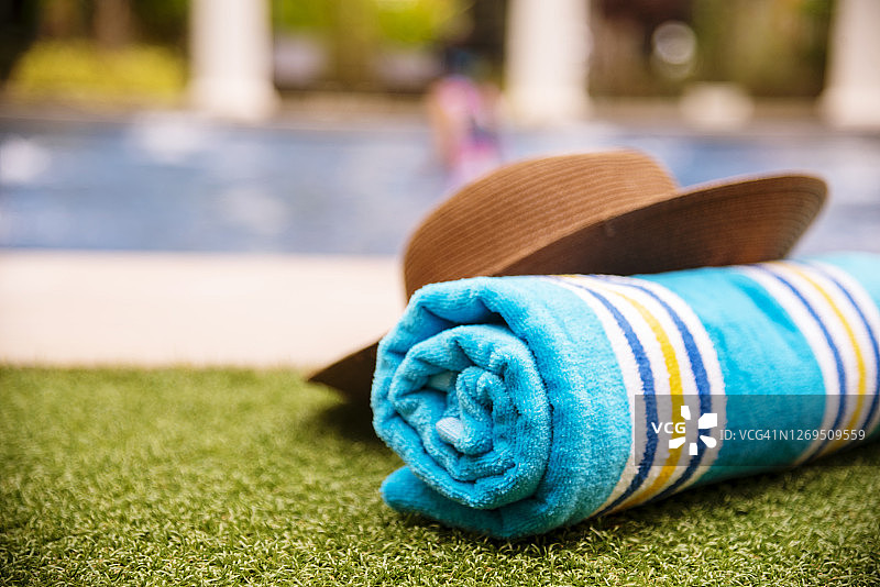 游泳池边的卷状沙滩巾，热带岛屿夏季概念图片素材