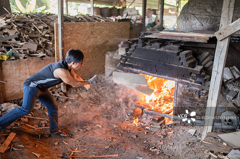 一位亚洲男人正在窑里烧制陶器图片素材