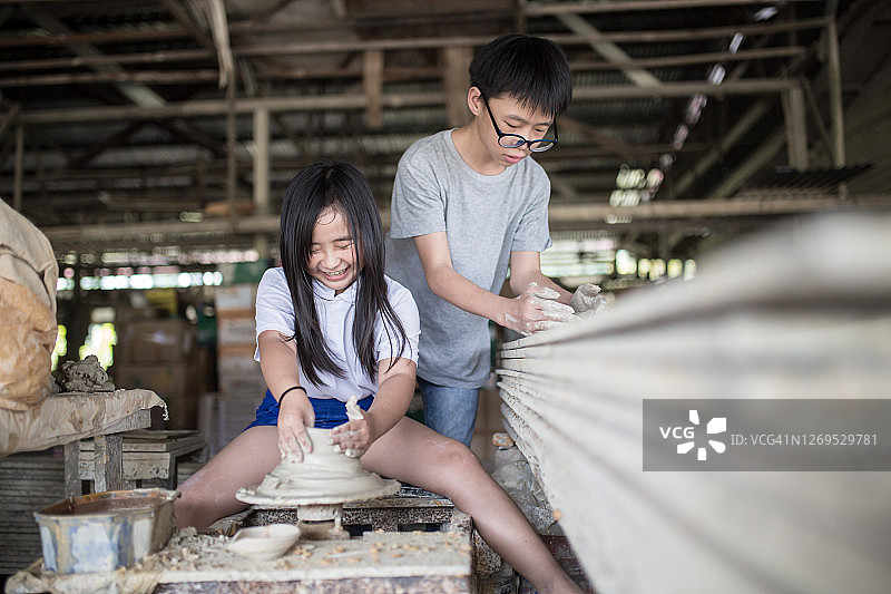 中国女孩与兄弟陶艺制作图片素材