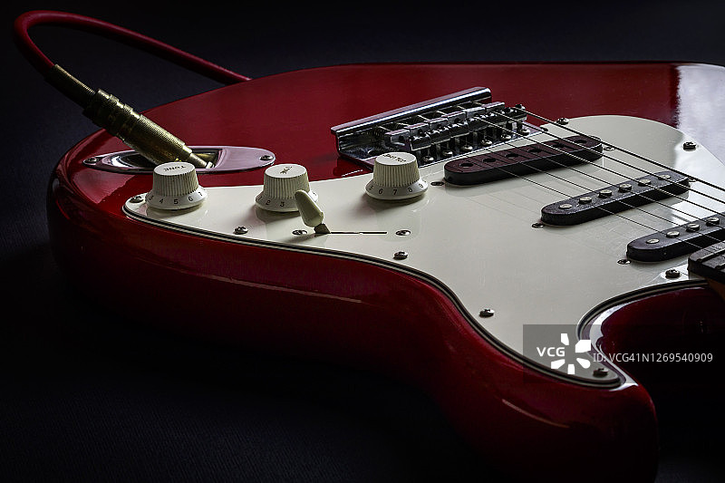 黑暗中环绕的红白色实体电吉他图片素材