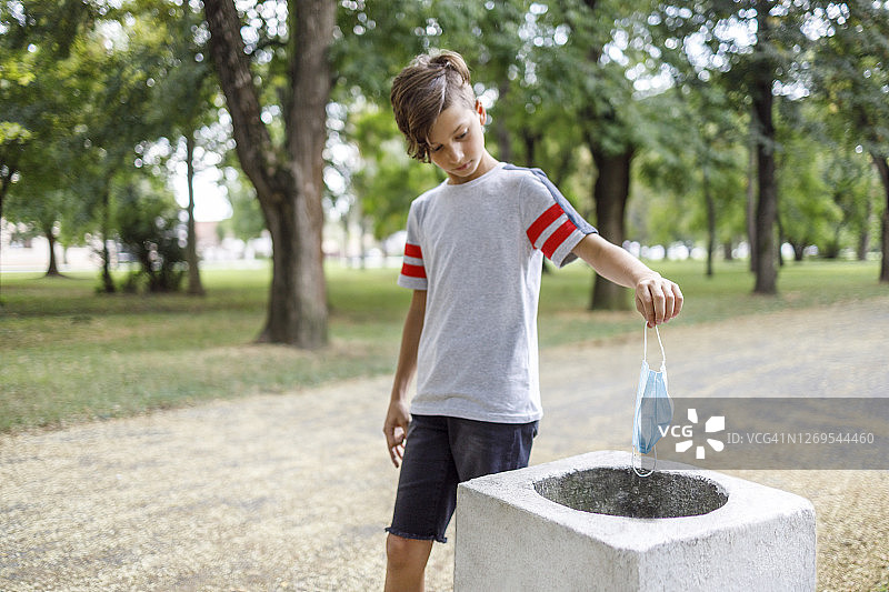 儿童在户外摘掉防护口罩图片素材