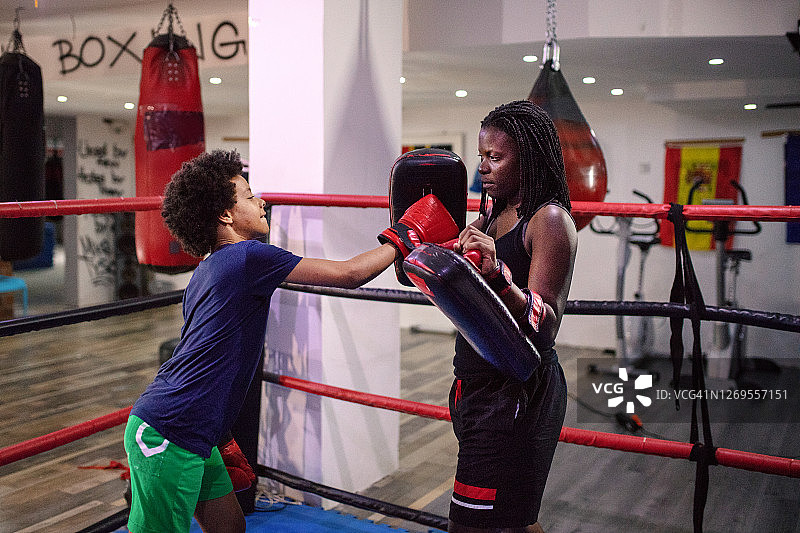 小女孩在健身俱乐部与教练练习跆拳道图片素材