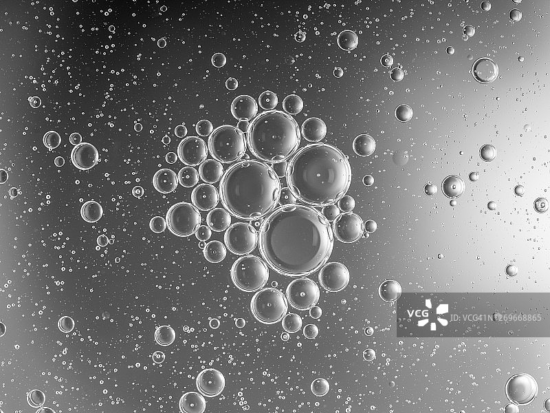 银色液体背景上的气泡和水滴形成的抽象形状和纹理图片素材