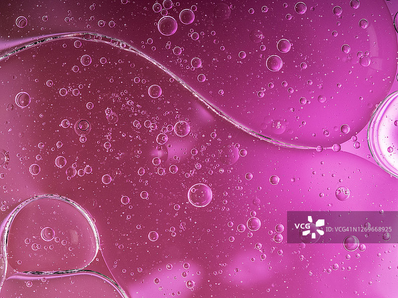 紫色液体背景上的气泡和水滴形成的抽象形状和纹理图片素材
