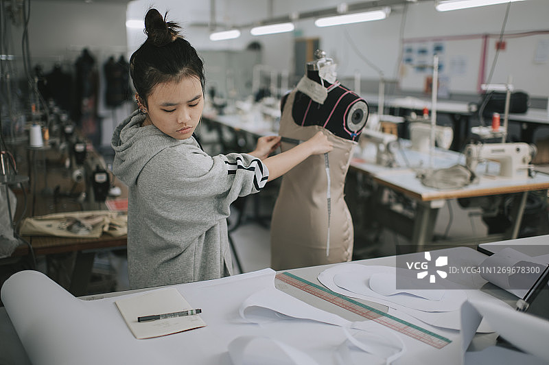 中国女大学生在学院工作室测量服装项目图片素材
