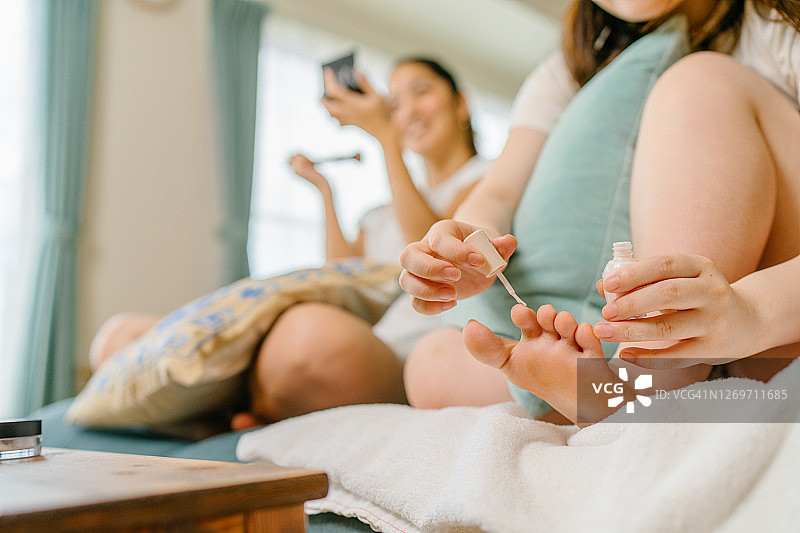 姐妹在家中客厅做美容护理图片素材