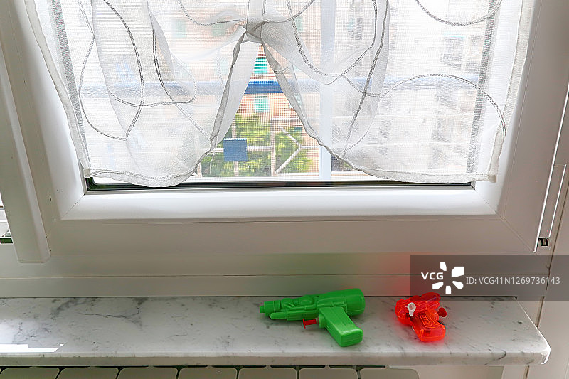 家居背景中孤立的红绿色玩具喷枪图片素材