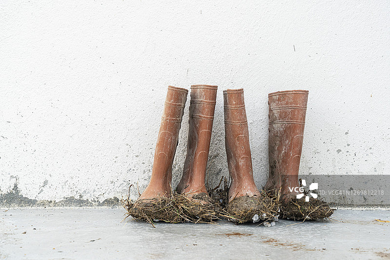 农场门阶上沾满泥土的棕色橡胶靴图片素材
