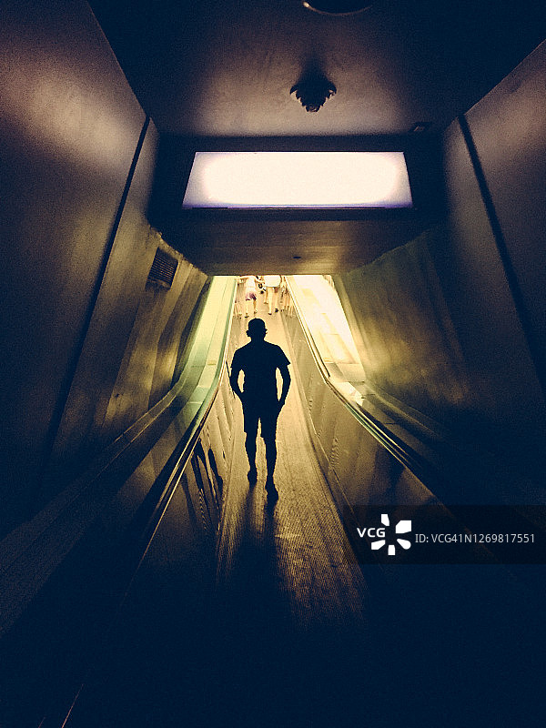 在狭窄隧道中行走的男人图片素材